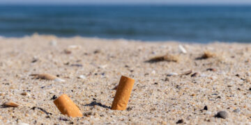 Sigarette nella sabbia. 📷 Depositphotos