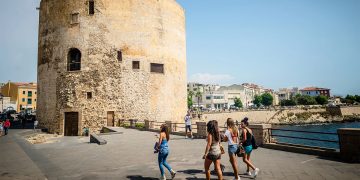 Turisti in giro per Alghero. 📷 Depositphotos